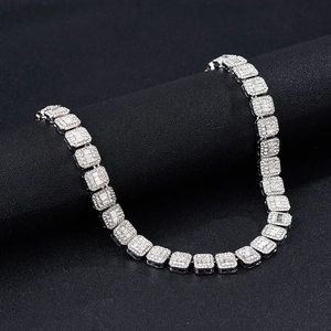 Détail d'une chaîne cubique argentée de 12 mm avec zircons baguettes sur un présentoir