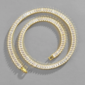 Macro view of gold tennis necklace featuring baguette-cut zircon stones and a fold-over clasp