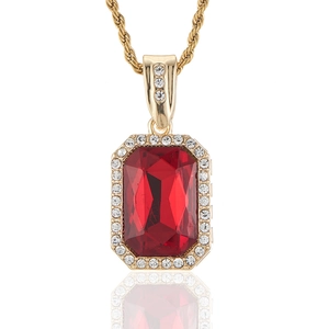 Macro shot of rectangular red gemstone pendant with white zircon halo on gold chain