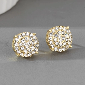 Détail macro de boucles d'oreilles rondes dorées avec pavé de cristaux blancs sertis