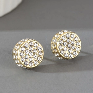 Détail macro de boucles d'oreilles rondes dorées serties de cristaux pavés brillants