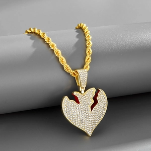 Dettaglio del ciondolo a cuore spezzato in oro con zirconi e catena a corda intrecciata