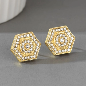 Gros plan sur des boucles d'oreilles hexagonales dorées ornées de strass étincelants