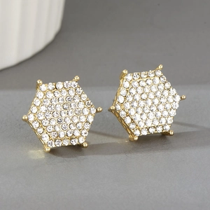 Détail macro de la boucle d'oreille hexagonale avec finition dorée et pavé de cristaux