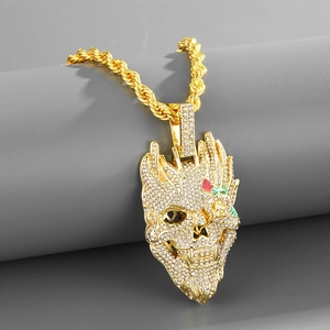 Gros plan du pendentif crâne serti de diamants avec yeux roses rouges et chaîne dorée