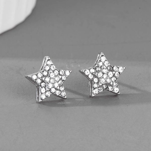 Détails d'une paire de boucles d'oreilles pentagramme en argent avec strass blancs