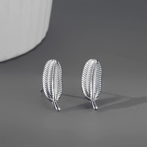 Détails des boucles d'oreilles plumes en argent avec texture ciselée et fini brillant
