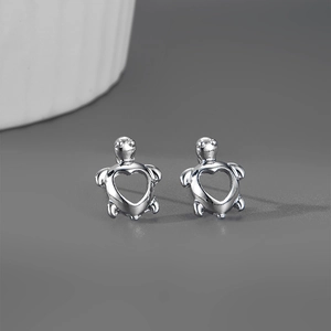 Détails des boucles d'oreilles tortue avec découpe en cœur et finition argentée polie