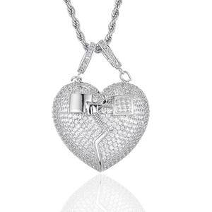 Détail du pendentif cœur brisé avec cristaux et chaîne torsadée sur fond blanc