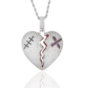 Détail macro du pendentif cœur brisé glacé avec croix et chaîne torsadée