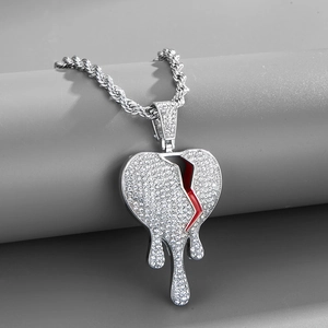 Détail du pendentif cœur brisé style hip-hop avec fissures rouges sur chaîne argent