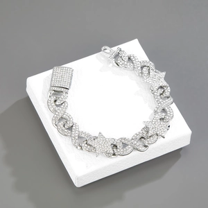 Detail of silver iced out hip hop bracelet with star and infinity symbols on jewelry box