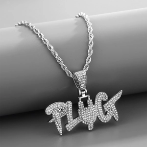 Detalle del colgante de letra PLUG con cristales sobre una gruesa cadena de plata