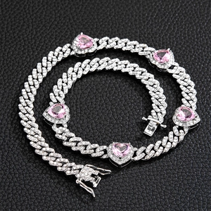 Makroaufnahme der silbernen kubanischen Kette mit rosa Herzsteinen und Mikro-Pave-Kristallen