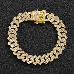 Vista macro del bracciale a catena cubana dorata da 12 mm con diamanti incastonati su pelle