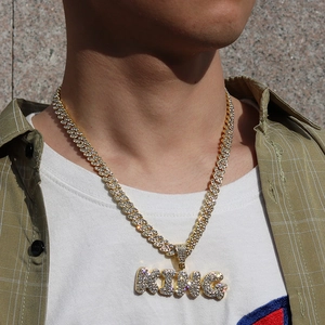 Detail der goldenen Panzerkette mit KING-Buchstabenanhänger und Zirkonia am Hals