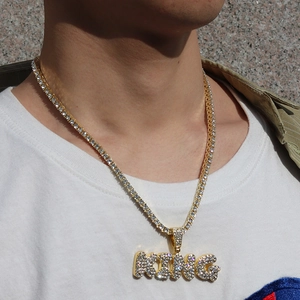 Nahaufnahme der Hip-Hop-Goldkette mit KING-Anhänger und Zirkonia am Modell im Freien