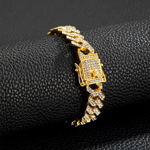 Vista ravvicinata del bracciale Cuban Link 12mm dorato con zirconi incastonati su pelle nera
