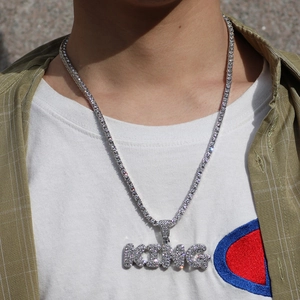Nahaufnahme der silbernen Hip-Hop-Tenniskette mit KING-Anhänger an einem männlichen Model