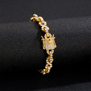 Close-up of gold iced-out Cuban link bracelet with clear rhinestones on black stand