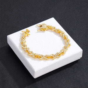 Macro detail of gold Cuban bracelet links with sparkling white rhinestones and clasp