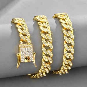 Détail d'une chaîne cubaine de 10mm dorée avec cristaux sur support à bijoux gris
