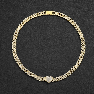 Detail of 9mm golden Cuban chain necklace with iced out heart pendant and crystals