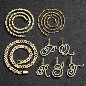 Detail of hip hop gold chains and cursive letter pendants with cubic zirconia inlay