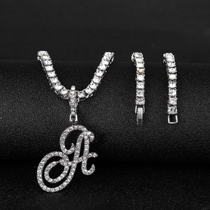 Detail of hip hop iced out cursive letter A pendant with matching chain and bracelet set