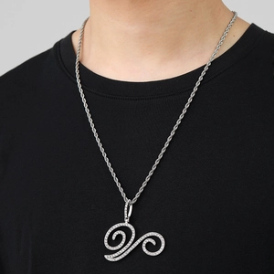 Detail of hip hop iced out cursive pendant on a silver rope chain worn by a model