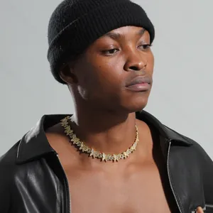 Gros plan d'un collier chaîne cubaine papillon serti de strass de luxe sur un mannequin
