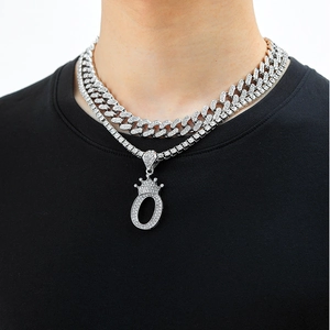 Close-up of hip hop layered necklace set with iced-out crown letter O pendant