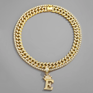 Close-up of gold Cuban chain and crown initial E pendant with shimmering crystals