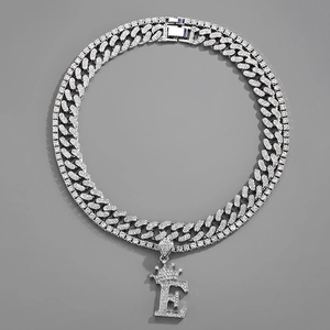 Detail of silver crown letter E pendant with iced-out cuban link chain set