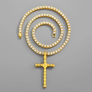 Vue macro de la chaîne tennis hip hop dorée avec pendentif croix et zircons blancs
