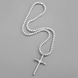 Gros plan sur la chaîne tennis argentée avec un pendentif croix serti de zircons