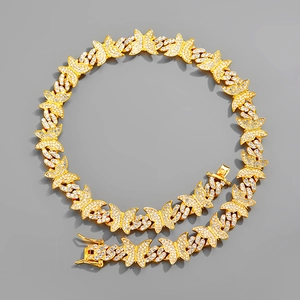 Détail du collier à maillons cubains dorés avec pendentif papillon et zircons brillants