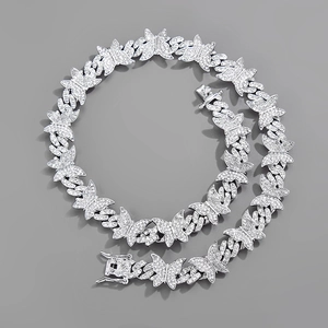 Détail macro du collier chaîne cubaine papillon argenté avec cristaux et fermoir de sécurité