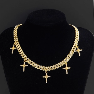 Detail van gouden Cubaanse ketting met vijf kruis hangers en zirkonia in iced-out stijl