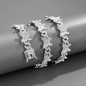 Gros plan de bracelets à maillons cubains avec pendentifs papillon et strass blancs
