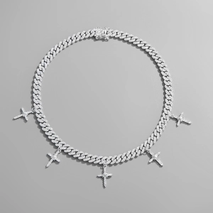 Detail van zilveren Cubaanse schakelketting met vijf kruishangers bezet met zirkonia