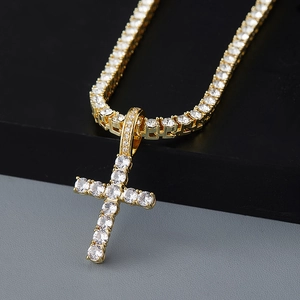 Vue macro d'un pendentif croix en or avec un collier de tennis brillant et strass