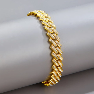 Gros plan d'un bracelet gourmette doré de 9,5 mm orné de strass brillants et polis