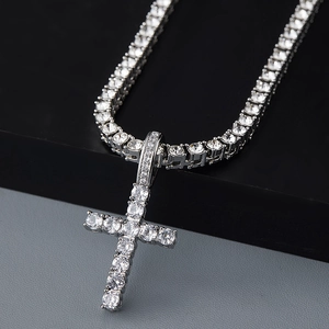 Vue macro du pendentif croix argenté serti de zircons avec une chaîne de tennis
