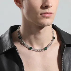 Iced out silver Cuban link chain with oval emerald green zircon stones on male model