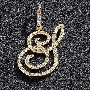 Detailed close-up of cursive letter S pendant in gold finish with micro-paved white zircons
