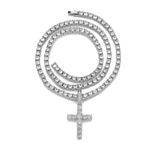 Gros plan du pendentif croix en argent scintillant et collier tennis avec zircons clairs