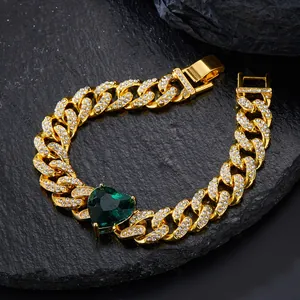 Macro shot of gold hip-hop Cuban chain with heart-shaped emerald green zircon stone