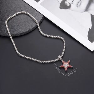 Detalle del colgante de estrella plateada con cristales rojos en collar tipo tenis