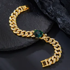 Detail of gold Cuban chain with emerald green heart stone and white zircon paving